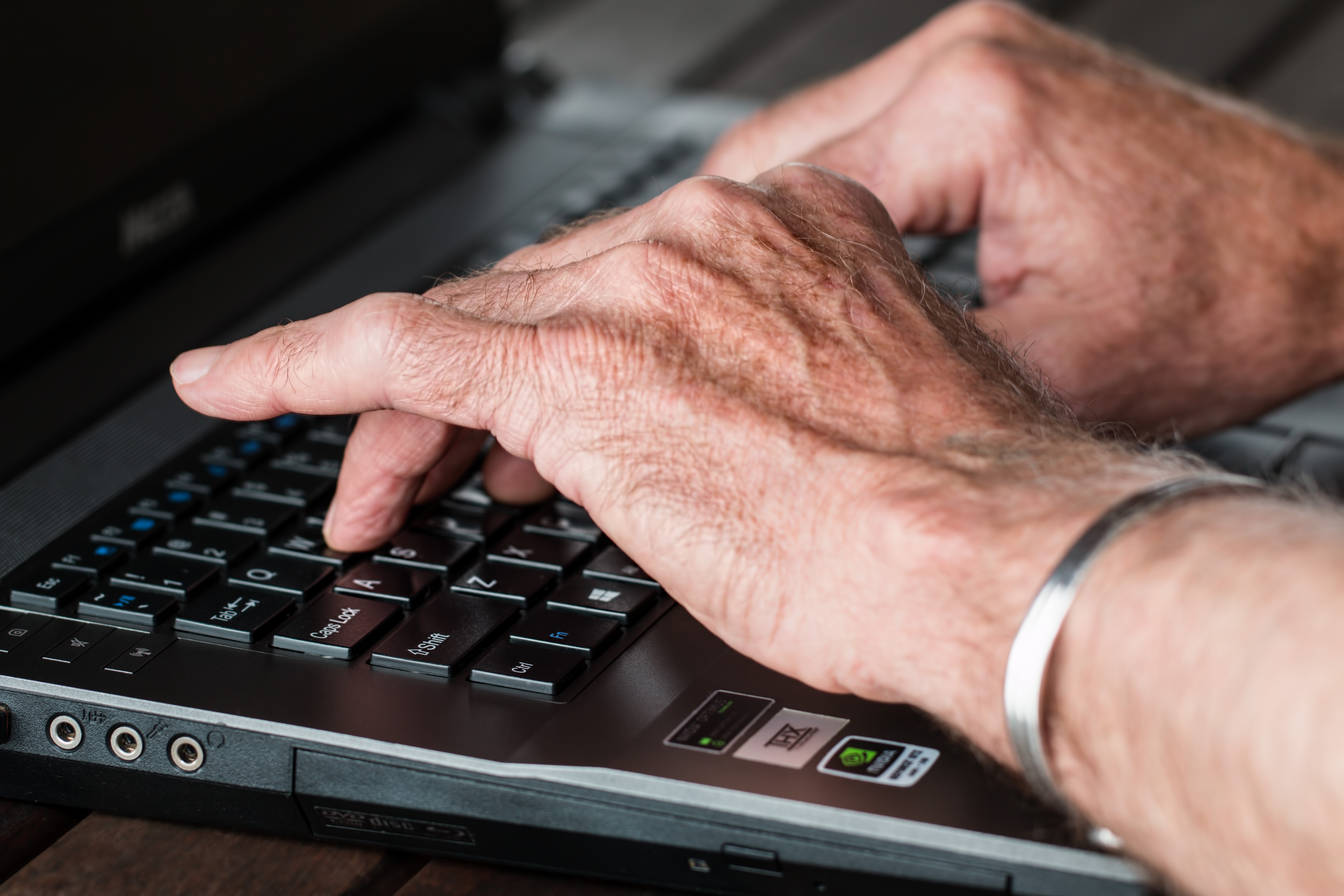 picture of elderly hands typing on a laptop
